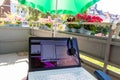 Home office on the balcony with headset and white laptop showing diagram chart and programs on screen on a table