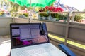 Home office on the balcony with headset and white laptop showing diagram chart and programs on screen on a table