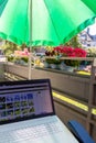 Home office on the balcony with headset and white laptop showing diagram chart and programs on screen on a table