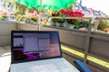 Home office on the balcony with headset and white laptop showing diagram chart and programs on screen on a table