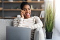 Home Office. Black Freelancer Woman Using Cellphone And Laptop In Living Room. Royalty Free Stock Photo