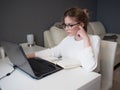 Home office, business girl with glasses working on a laptop. Royalty Free Stock Photo