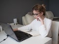 Home office, business girl with glasses working on a laptop. Royalty Free Stock Photo