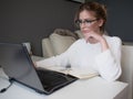 Home office, business girl with glasses working on a laptop. Royalty Free Stock Photo