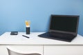 Home office of a creative entrepreneur with black laptop, empty white chair during lunch break. Modern creative workspace with Royalty Free Stock Photo