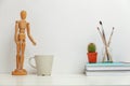 Home or office decor with mannequin coffee cup near white wall