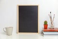 Home or office decor with mock up blank chalkboard on table near white wall Royalty Free Stock Photo