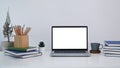 Home office desk with laptop, coffee cup, house plant and boxes on white table. Royalty Free Stock Photo