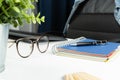 Home office desk and empty chair. Notebook, pen and glasses on desk. Working at home, freelance, successful business concept Royalty Free Stock Photo