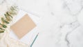 Home office desk table concept. Minimal flat lay style composition with paper notebook, pencil, eucalyptus, woman scarf on white