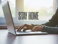 Home office with freelancer hands with laptop and text Stay home