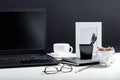 Home Office laptop workspace. Desktop with laptop pc smart phone, notepads pens office suppliers cup of coffee drink Royalty Free Stock Photo