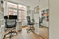 a home office with a large window and two desks