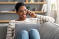 Home Office. Positive African Freelancer Lady Talking On Cellphone And Using Laptop Royalty Free Stock Photo