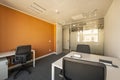 Home office with small white wooden tables, a glass wall, gray carpet Royalty Free Stock Photo