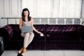 Home office. Successful young beautiful woman sitting on a sofa in the living room and using laptop, holding coffe cup Royalty Free Stock Photo