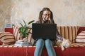 Home office, work space, work from home concept. Young woman with laptop and cat working at sofa. Flexible work hours Royalty Free Stock Photo