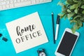 Home office and working from home concept. Table workplace with keyboard computer, notepad and smartphone. Top view from above