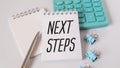 Home office workspace with keyboard, clipboard and pen with text NEXT STEPS on a white white background , business concept Royalty Free Stock Photo