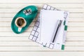 Home office workspace mockup with notebook, pen, cup of coffee, alarm clock and accessories on white wood desk background. Top Royalty Free Stock Photo
