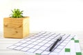 Home office workspace mockup with notebook, pen, plant in wooden potted and accessories on white wood desk background, copy space Royalty Free Stock Photo