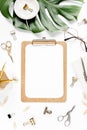 Home office workspace mockup with tropical leaves Monstera, clipboard, and accessories on white background. Flat lay Royalty Free Stock Photo