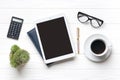 Home office workspace. Tablet, glasses, notepad, cup of coffee, pen, succulent on white wooden background. Top view Business,