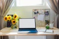 Home office workspace. Wooden desk with laptop mockup white empty screen, mood board with pined notes and photos