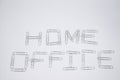 `Home office` written with metal paper clips on the white paper background. Flat lay. Stay home. Remote work. Remote education. Qu