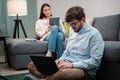 Home office of a young couple of employees, the girl works using a tablet, the guy a laptop Royalty Free Stock Photo