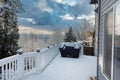 Home outdoor deck closed for the winter with snow on BBQ cooker cover Royalty Free Stock Photo