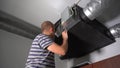 Home Owner Removing Dirty Air filter for home central air recuperation system