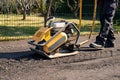 Home owner use plate compactor tool to build parking lot with recycled asphalt.