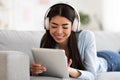 Home Pastime. Asian Girl Using Digital Tablet And Listening Music In Headphones Royalty Free Stock Photo
