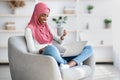 Happy Black Muslim Woman Relaxing With Laptop And Drinking Coffee At Home Royalty Free Stock Photo