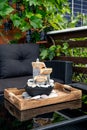 Home patio with black plastic garden furniture, small relaxing electrical zen table fountain on table and real grape vines.