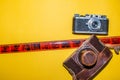 Camera, leather bag and tape for the picture. Yellow background and camera. Design for a photo studio