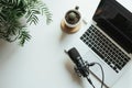 Home podcast setup with a microphone, laptop on a clean white desk, ready for recording Royalty Free Stock Photo