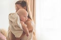 Home portrait of a newborn baby with mother on the bed. Mom holding and kissing her child. Royalty Free Stock Photo