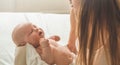 Home portrait of a newborn baby with mother on the bed. Mom holding and kissing her child. Royalty Free Stock Photo