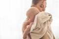 Home portrait of a newborn baby with mother on the bed. Mom holding and kissing her child. Royalty Free Stock Photo