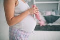 Home portrait of young pregnant woman preparing for childbirth and doing everyday homework at nursery. Royalty Free Stock Photo