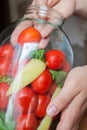 Home preserving of tomatoes. the hand settles the tomatoes in a jar for canning for the winter. Royalty Free Stock Photo