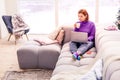 Pretty young beaming girl in a violet sweater spending a day at home