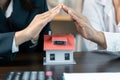 Home protection concept, close up of female hands sheltering modern house, get insurance or loan real estate or property. Approved Royalty Free Stock Photo