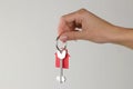 Home purchase concept. Keys with a keychain house in hand on a light background Royalty Free Stock Photo
