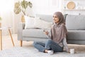 Home Relax. Muslim girl with smartphone and coffee unwinding in living room