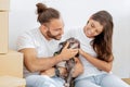 Positive young diverse couple stroking their dog in new home Royalty Free Stock Photo