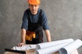 home renovation and architecture concept man in hard hat examines plans and blueprints. Builder engineer indoors with Royalty Free Stock Photo