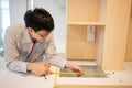 Asian male furniture assembler using tape measure Royalty Free Stock Photo